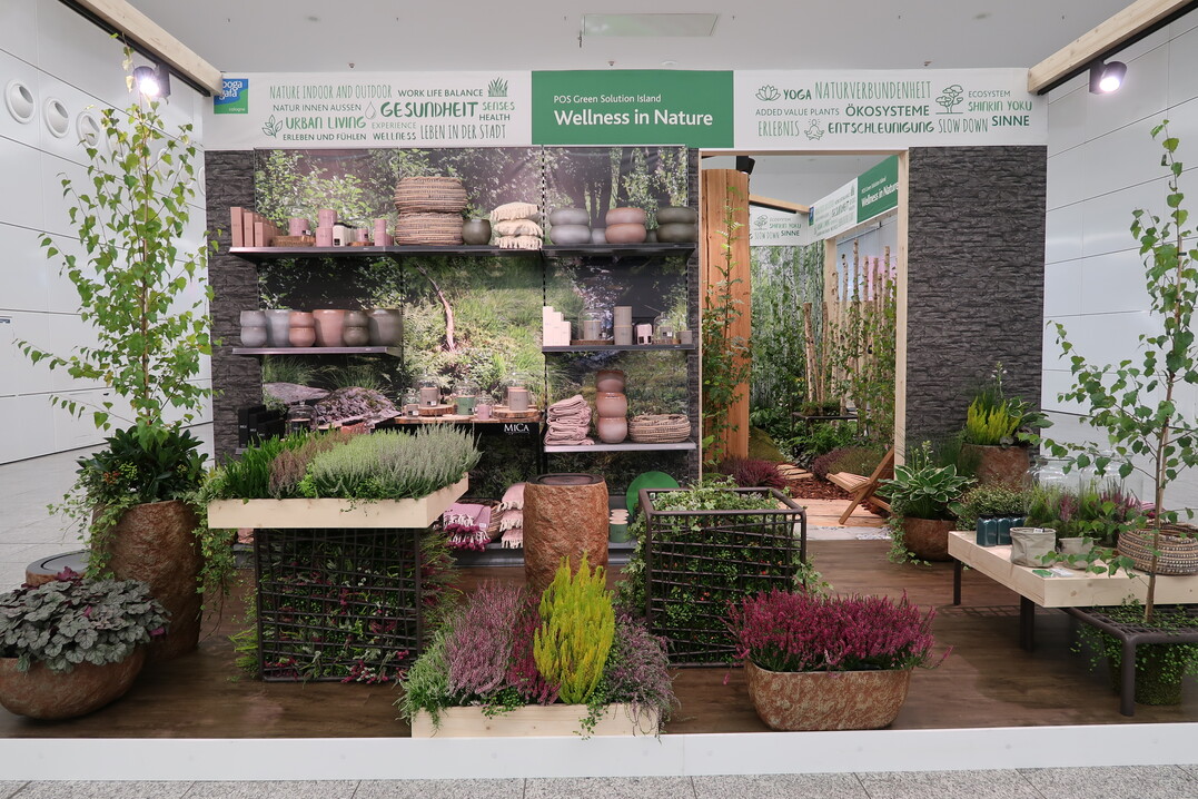 Die Insel Wellness in Nature setzt die Natur als Ort der Entspannung und Entschleunigung in Szene. Einfach mal abschalten ist im Zeitalter der Digitalisierung und Urbanisierung gar nicht so leicht. Deshalb schwappt aktuell ein Trend aus Japan zu uns herber: Shinrin-yoku, das Waldbaden. Oliver Mathys und Konnie van Delft bersetzten dies in ein Indoor-Naturerlebnis. In der Mitte der Insel auf 18m fhrte ein geschwungener Pfad aus Rindenmulch, Holzdielen und Steinen durch einen begrnten Raum. Zahlreiche Pflanzen, Mooswnde und Birkenstmme stilisieren ein Stck Natur, es riecht nach Holz, eingespieltes Vogelgezwitscher macht das Naturerlebnis perfekt. Zahlreiche Sitzmglichkeiten bieten dem Kunden die Gelegenheit zur Einkehr, zur Entspannung und zum stillen Genieen. An den Kopfseiten der  Insel waren exemplarische Verkaufsflchen fr die Vertriebskanle Baumarkt und Gartencenter gestaltet, die eine Sortimentsauswahl zeigten, die es dem Kunden ermglicht, sich auch zu Hause eine kleine Oase zu schaffen.