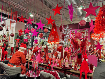 Am Stand der Firma AM Design sind die Farben Pink und Rot der Eyecatcher. Der Tischaufbau mit den Weihnachtsmnnern lsst sich einfach umsetzen und mit roten Weihnachtssternen ergnzen. Wer keine Schaufensterfiguren hat, kann die Weihnachtsmannanzge mit Holzwolle ausstopfen und den Kopf aus beigefarbenem Stoff (auch mit Holzwolle gefllt) mit einem Bart und einer roten Nase und der Nikolausmtze ber den Augen nachbilden. Diese Inszenierung wrde auch als traditioneller Aufbau in Rot/Grn wirken. Der Tisch dient als Inspiration fr die Besucher des Gartencenters. Die Ware zum Kauf sollte in der Nhe zur Verfgung stehen. 
