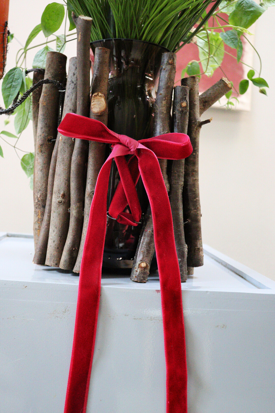 Die �sen mit Samtband verbunden, ergeben eine festliche, weihnachtliche Stimmung. Da die Vase im Inneren herausgenommen werden kann (einfach die H�lle abheben), ist dieses Grundkonzept auch f�r Laien einfach wieder zu bef�llen. Die H�lle ist schwer und kompakt, gibt damit der inneren Vase Standfestigkeit. Eine weite Vasen�ffnung ist zu empfehlen.