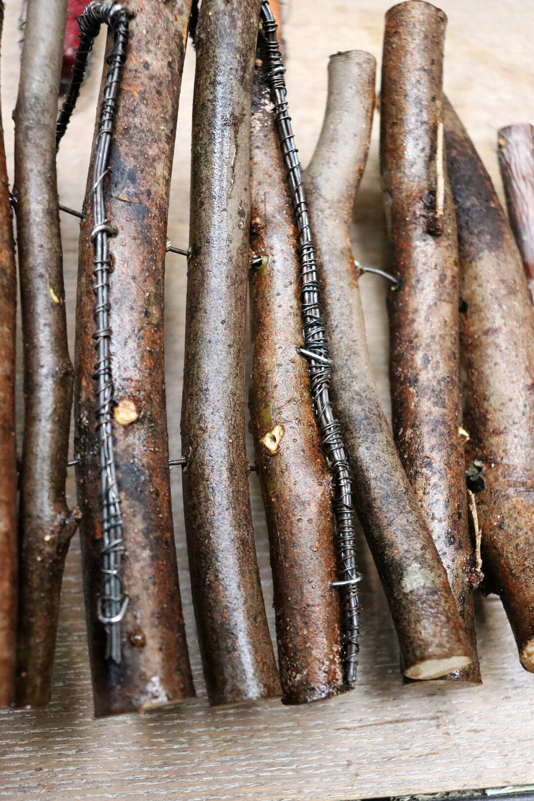 Eine andere Art, die Kerzenhalter zu befestigen, ist, die Dr�hte mit Krampen in den �sten zu verankern. Wichtig ist, dass die Stiele der Kerzenhalter lang sind, um das Gewicht der Kerzen auszubalancieren. Die H�llen selbst werden nicht in der Mattentechnik verwoben, daf�r sind die Astvarianten zu schwer. Sie werden auf Spanndraht aufgef�delt. Daf�r m�ssen L�cher gebohrt werden, ja, die H�llen sind eine aufwendige Technik.