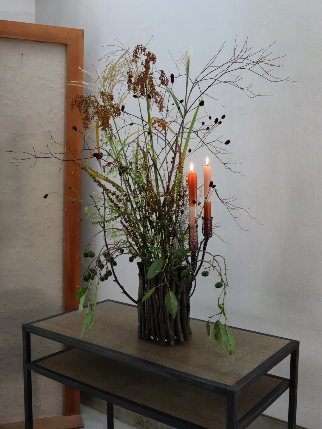 Jahreszeitenunabh�ngig: Auch zur sp�tsommerlichen Zweigh�lle mit 
<i>Suzuki</i>
-Gr�sern, 
<i>Sanguisorba</i>
, 
<i>Alnus </i>
und 
Sauerampfer passen Kerzen. Zudem ist durch den technisch geschaffenen Sicherheitsabstand auch der Einsatz von Trockenblumen denkbar. 