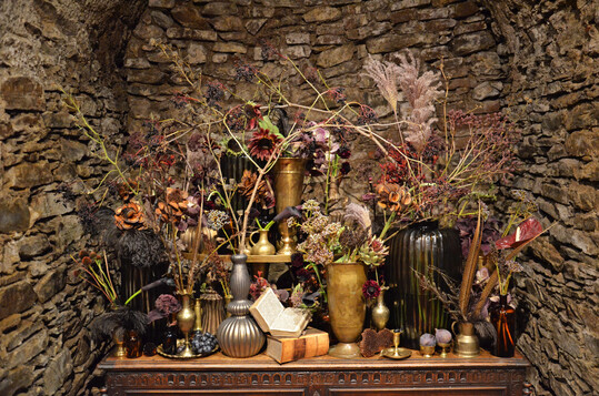 Perfekte Symbiose: Bei der Gefäßfüllung von
<b>Sarah von Aarburg </b>
treffen metallischer Glanz auf tiefes Violett und edle Blüten.