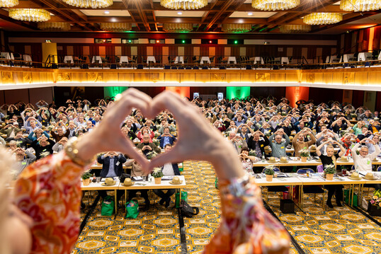 Die 320 Teilnehmerinnen und Teilnehmer zeigen das Herzzeichen (together) als Hinweis auf den Kongress der International Garden Centre Association (IGCA) 2026 in Deutschland.