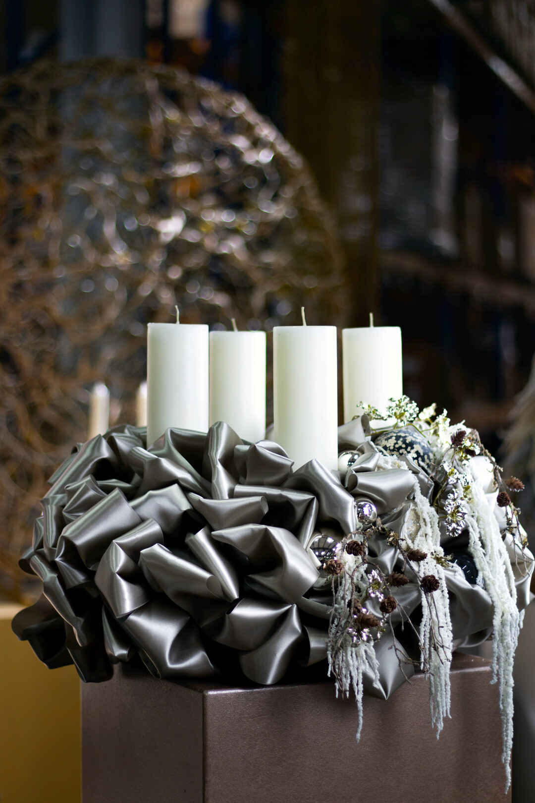 Ein edler Blickfang in khlem Metallic-Look: Dieser Kranz aus geflteltem Satinband zeigt, wie glamours moderne Adventsfloristik wirken kann  ganz ohne berladen zu sein. Feine Eiskristall-Accessoires und kaskadierende Dekoelemente verleihen ihm Bewegung und Tiefe.