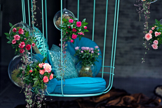 Bcherstapel, ein Vintage-Sessel, weiches Licht und Rosenarrangements schaffen im Schaufenster eine Atmosphre wie aus einer Liebesszene.