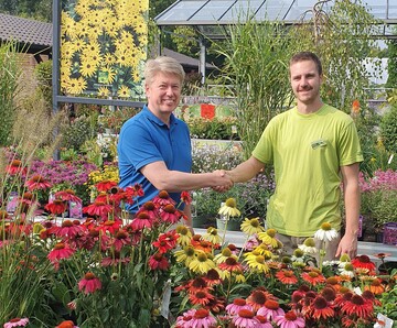 Thomas Buchenau (links) berreicht Jonas Hellerberg, Geschftsfhrer des Gartencenters FloraWelt in Dorsten, das Gtesiegel.