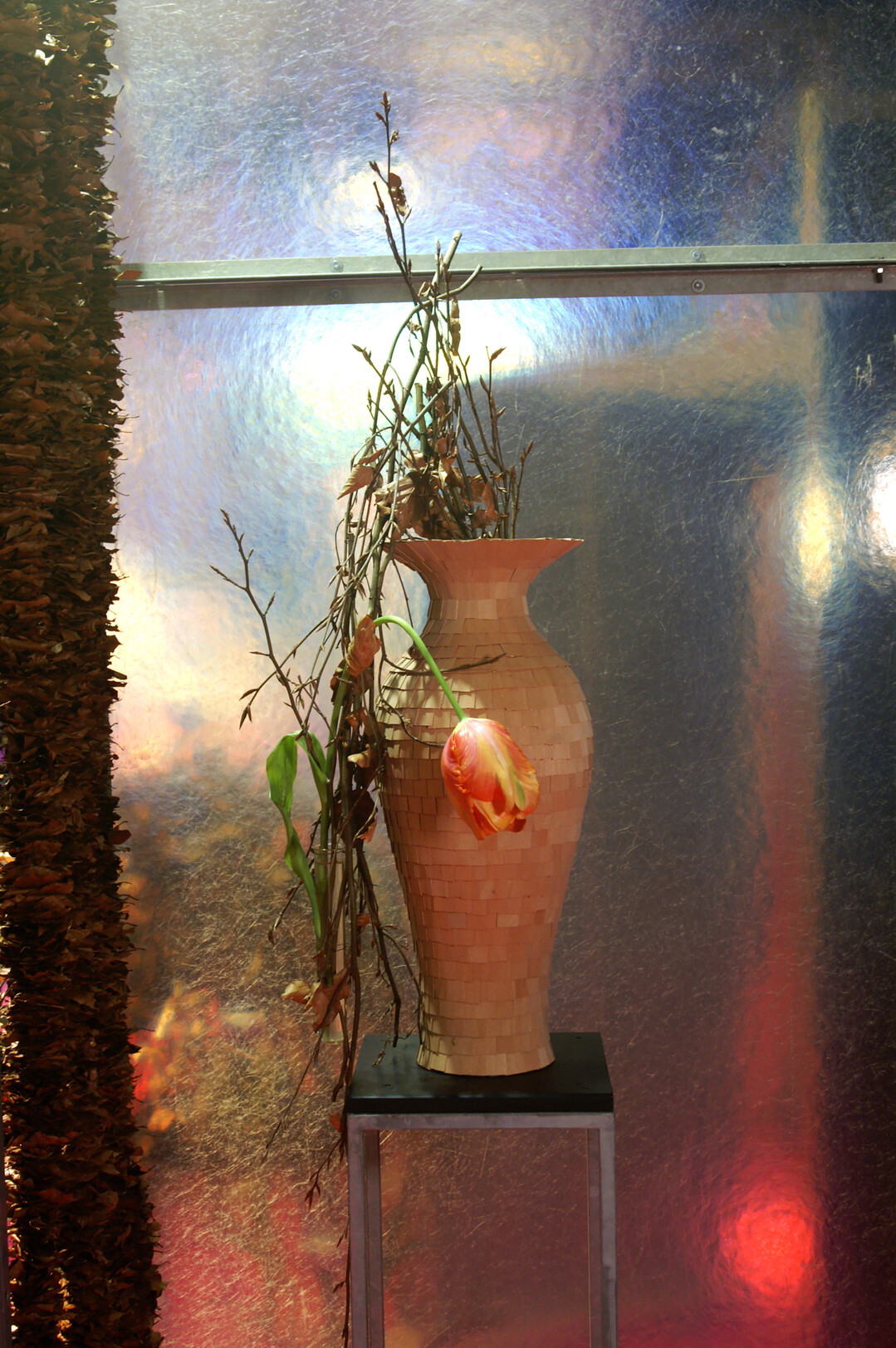 Die Vase bekam ein neues Kleid. Kay Renner klebte Furnierholz-Bl�ttchen dachziegelartig an. Durch sparsame Hinzunahme von anderen Floralien steht die Vase im Fokus.  