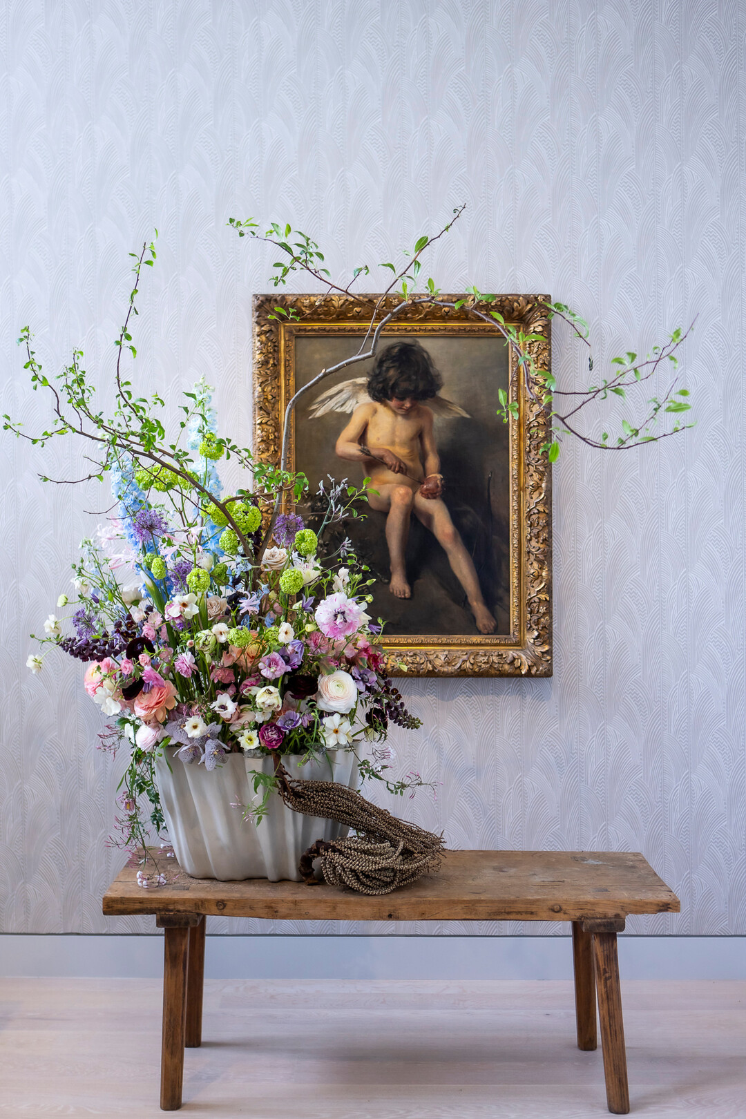 Das Team um den Floristen Victor Breuer kreiert ein Arrangement aus zarten Blten
des Sptfrhlings wie Iris, Ranunkeln, Anemonen, Tulpen, Clematis und Rittersporn,
gesteckt zwischen Quittenzweige, vor Amor, einen Pfeil in ein Herz stechend von Sally Kgelgen.