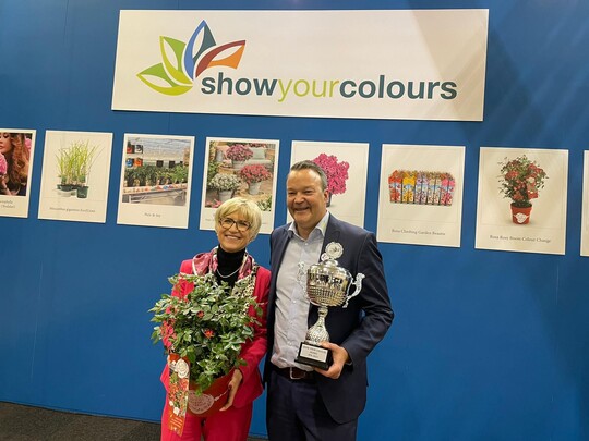 Die Rosa Rosy Boom Colour Change von Diderk Heinje Pflanzenhandelsgeschaft, Edewecht (DE) wurde mit dem Show Your Colours Award IPM 2023 ausgezeichnet.Mit seinem einzigartigen Farbverlauf von Rot bis Lila und seinen duftenden Blten ist der winterharte Rosa Rosy Boom Colours Change ein fantastischer Geschenkartikel. Darber hinaus ist es ein einfacher und gesunder Strauch, so die Fachjury. Im Namen der IPM-Organisation berreichte Eva Khler-Theuerkauf den Preis am Stand von BIZZ Holland an Sebastian Heinje.