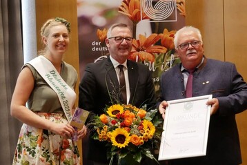 Die Deutsche Blumenfee Regina Haindl und ZVG-Prsident Jrgen Mertz berreichten die ZVG-Ehrennadel in Gold an Matthias Melchisedech (rechts) aus Trier.