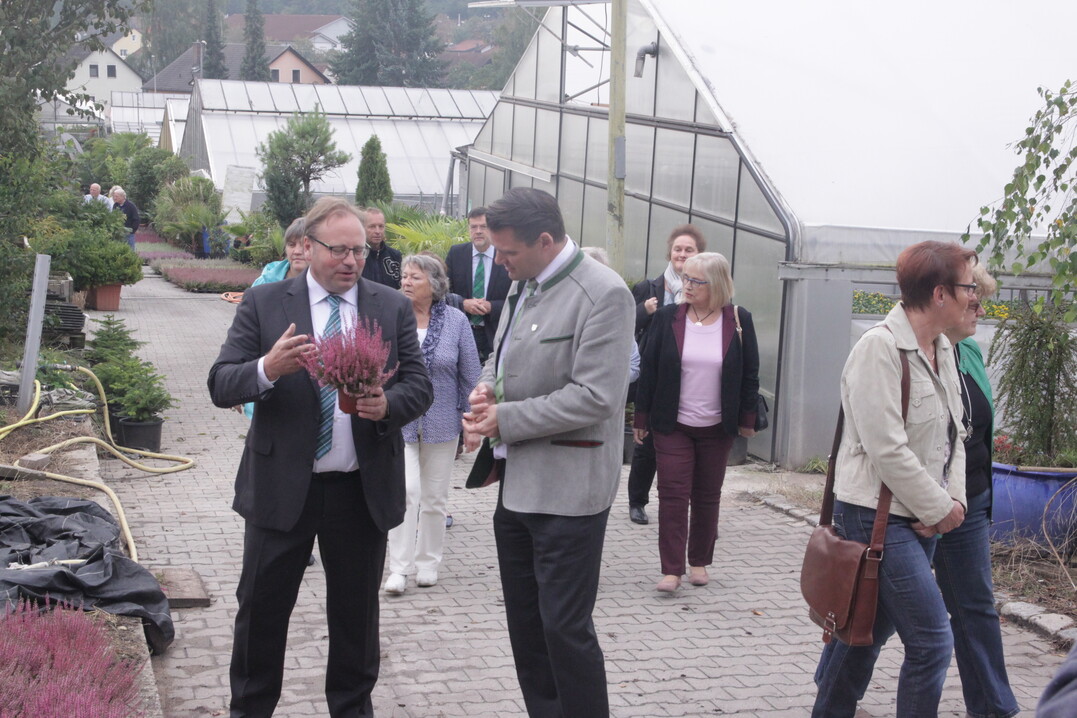 Bernd Fischer stellt Thomas Ebeling, Schirmherr und Landrat des Landkreises Schwandorf, auf einem Rundgang durch seine Gärtnerei in Burglengenfeld Bienenpflanzen für den Herbst vor.