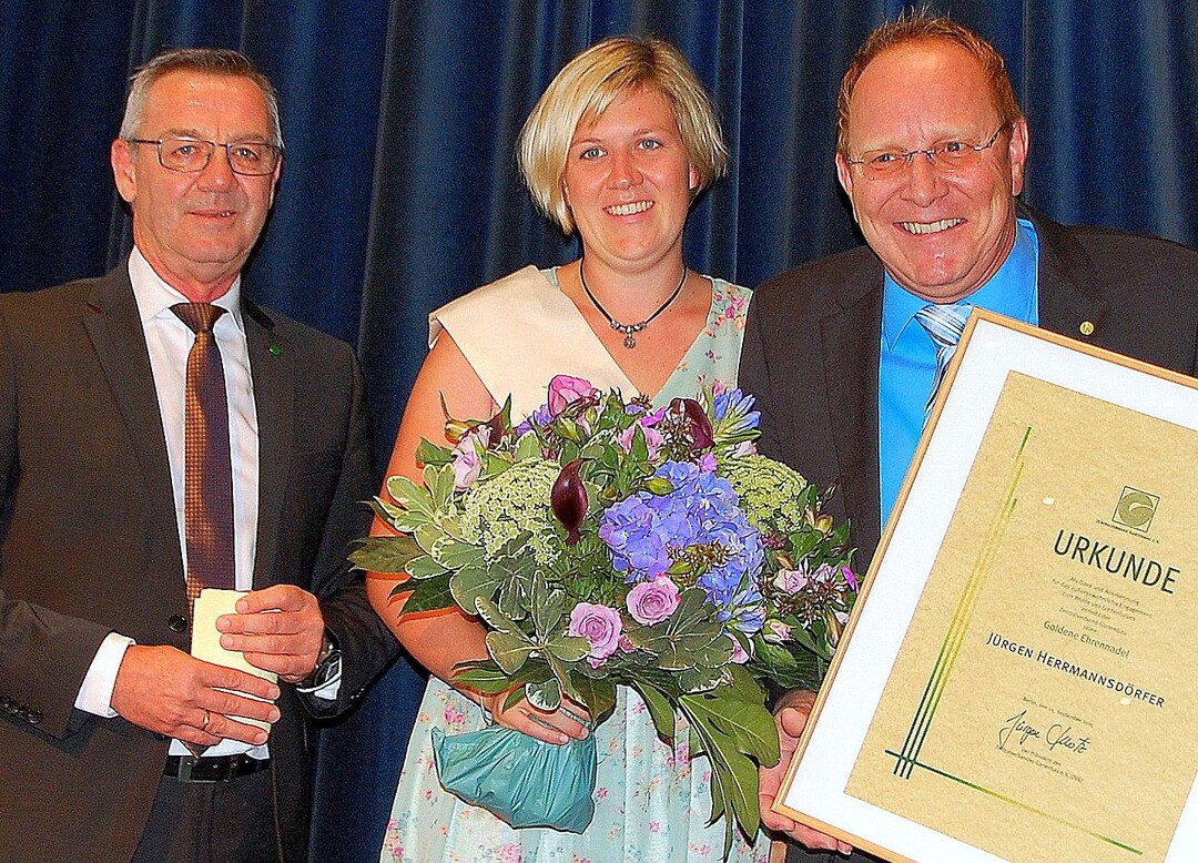 Jürgen Mertz, Präsident des Zentralverband Gartenbau e.V. und die neue Deutsche Blumenfee, Alexandra Berchtenbreiter, gratulieren Jürgen Herrmannsdörfer (re.) zu seiner Ehrung